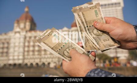 A man considers Indian 500 rupees on Mumbai street. Hands close up. Stock Photo