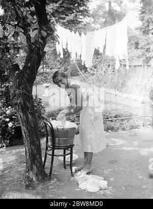 Doing the laundry in the 1960s. A lady is using a washboard to clean the  dirty laundry. The tool was designed for hand washing clothing rubbing them  agains the series of ridges