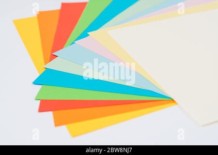 laid out bright multicolored paper on white background, flat lay Stock Photo
