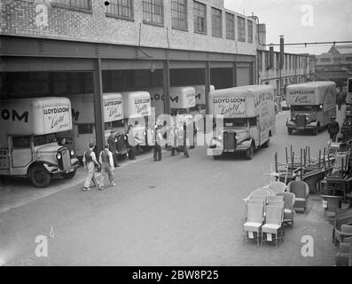 The forecourt of Lloyd loom , lusty furniture produce factory , with drivers and loaders having a quick catch up in front of the company Bedford lorrys . To the right of the photo can be seen some of the companys furniture. 1938 Stock Photo