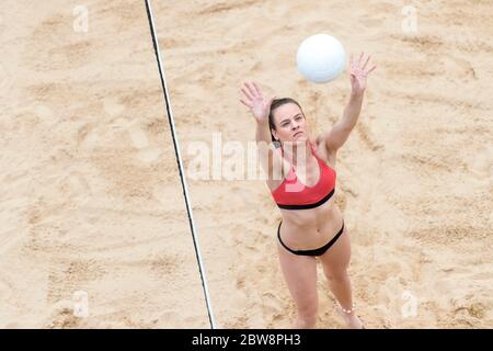 Young woman with white ball playing volleyball on beach. Summer vacation and sport concept Stock Photo