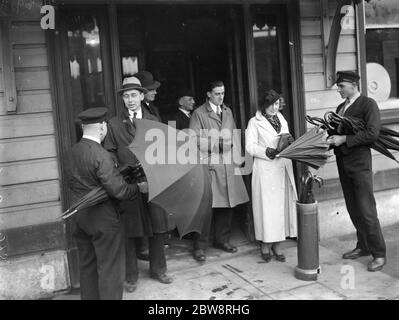 Umbrella service , New Eltham Street . Handing out umbrellas to members of the public . 1935 Stock Photo