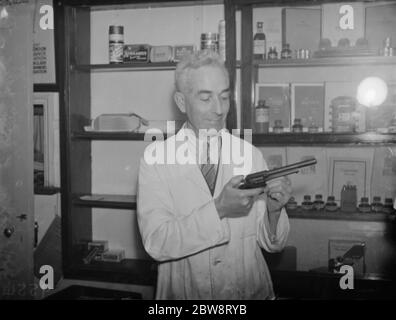 Mr Gregory May holds the .357 Magnum revolver weapon used during the armed robbery at Downe post office . 8 September 1938 Stock Photo