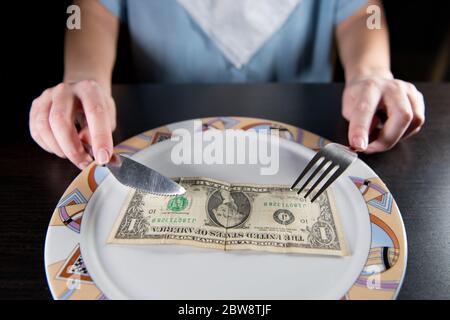 one dollar bill on a girl s plate. The concept of poverty and cheap food Stock Photo