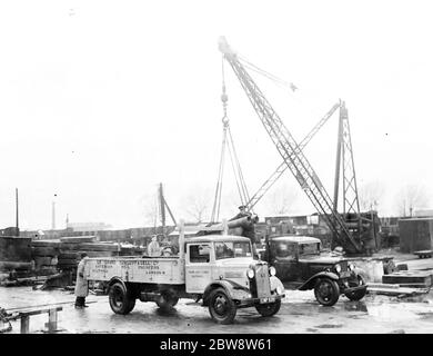 Bedford lorries belonging to Le Grand Sutcliff and Gell Ltd from Southall Londond , loading up at a freight station . 1936 . Stock Photo