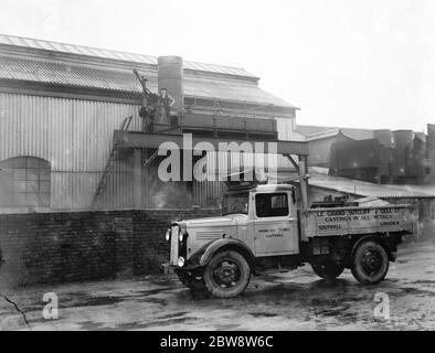 Bedford lorries belonging to Le Grand Sutcliff and Gell Ltd from Southall Londond , loading up at a freight station . 1936 . Stock Photo