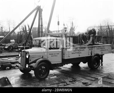 Bedford lorries belonging to Le Grand Sutcliff and Gell Ltd from Southall Londond , loading up at a freight station . 1936 . Stock Photo