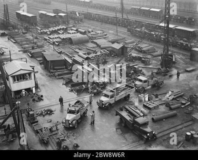 Bedford lorries belonging to Le Grand Sutcliff and Gell Ltd from Southall Londond , loading up at a freight station . 1936 . Stock Photo