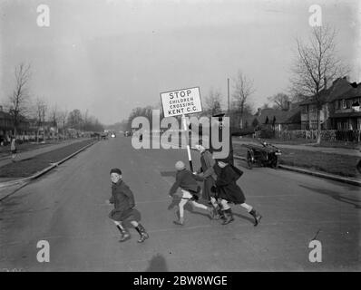 Road attendant from Kent County Council , holding a sign , helps children in St Mary Cray cross the road . 1938 Stock Photo