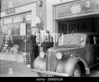 The famous cinema organist , Mr Robinson Cleaver , shaking hans with Mr Lewis Evans next to a Vauxhall car . 10 February 1939 Stock Photo