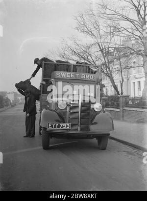 Workers are unloading sacks from a Bedford Lorry belonging to Sweet Bros the coal merchant , on their delivery . 1939 Stock Photo