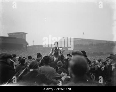 Dave Mangnall , the Millwall captain , being carried aloft by the crowds that have swarmed the pitch , following the FA Cup victory of Millwall against the favorites , Manchester City , at ' The Den ' stadium in New Cross , London . Magnall scored the two goals that took Millwall through the quarterfinals . 1937 Stock Photo