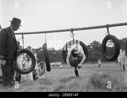 Sports day at Eltham Central School in London . Diving through a tire on the obstacle course . 16 June 1937 Stock Photo