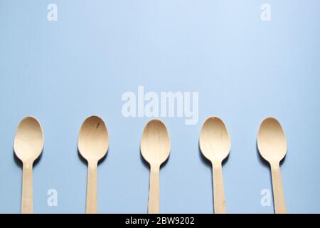 Spoons are arranged in a row. Eco-friendly tableware from wood. Stock Photo