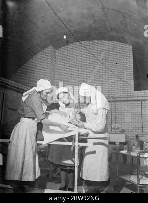 An emergency underground hospital in Erith , London . Nurses ' perform ' eye surgery during a training drill . 1939 Stock Photo