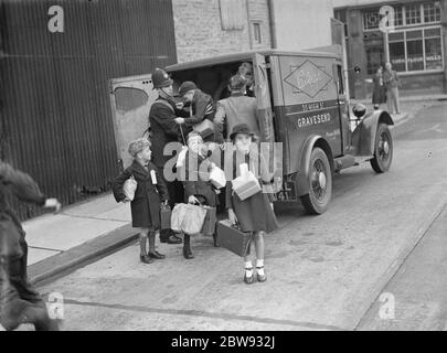 In response to the dangers of war the British government launched a scheme to evacuate the children from major urban centers to private housing in more rural areas . Photo shows a policeman helping children from the back of a van in Gravesend , Kent , during evacuation procedures . 1939 Stock Photo