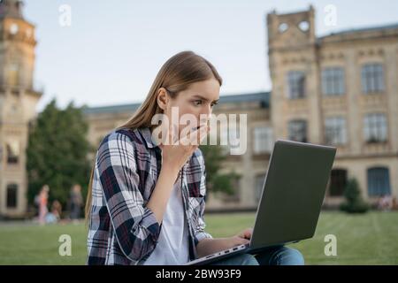 University student with shocked scared face reading bad news, exams failure. Woman freelancer using laptop computer, she missed deadline Stock Photo