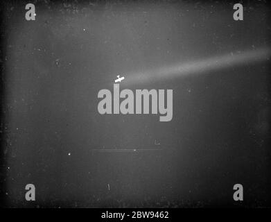 An anti aircraft display in Dartford , Kent . An aeroplane is caught by a searchlight in the demonstration . 1938 Stock Photo