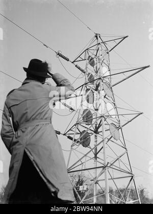 A man stands looking up at an electricity pylon in Shoreham , Kent . 1936 Stock Photo