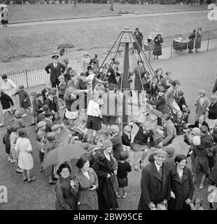 Children playing on the top hat roundabout at the children 's playground in Crayford , Kent . 1936 Stock Photo