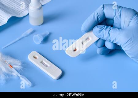 Express COVID-19 test for IgM and IgG antibodies to novel coronavirus SARS-CoV-2, Covid-19. Nurse hand in glove collects patient blood with disposable Stock Photo