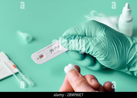 Express COVID-19 test for IgM and IgG antibodies to novel coronavirus SARS-CoV-2, Covid-19. Nurse hand in glove with positive coronavirus test. Patien Stock Photo