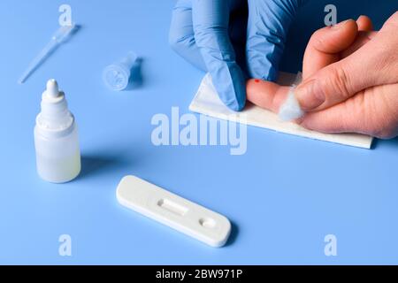 Express COVID-19 test for IgM and IgG antibodies to novel coronavirus SARS-CoV-2, Covid-19. Nurse hand in nitril glove collects patient blood with dis Stock Photo