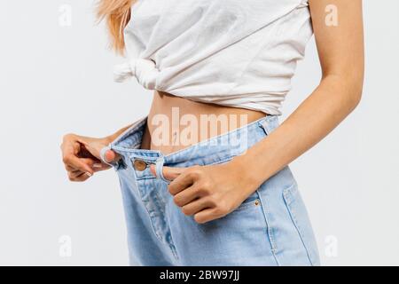 Closeup of woman with large waist and big sides pulling up leggings on  beige background. Body positive. Accepting who you are. Tight clothes. Need  for Stock Photo - Alamy