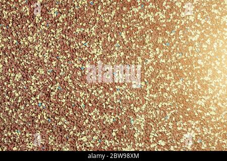 Background of granular stone texture in brown and yellow colors with lens flare. Grain material of wall or flooring. Stock Photo