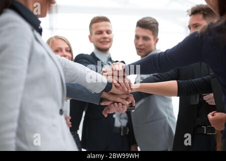 young employees making a stack out of their hands Stock Photo