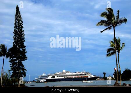 Cruise ships dock at Hilo Bay for a Port of Call.  Smaller boats anchor alongside and look like toys compared to the size of the bigger boat. Stock Photo