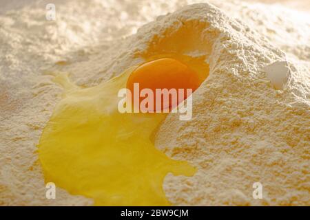 Broken egg in flour, on wood table Stock Photo