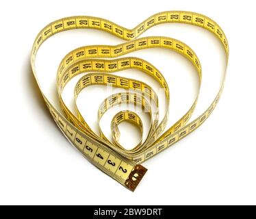 Heart made of yellow measuring tape isolated on a white background. Stock Photo