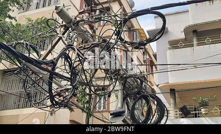 High tension electric wires hanging dangerously from a broken pole on a city road after cyclonic storm 'Amphan' struck landfall at Kolkata, India Stock Photo