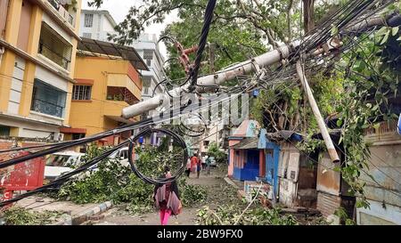 High tension electric wires hanging dangerously from a broken pole on a city road after cyclonic storm 'Amphan' struck landfall at Kolkata, India Stock Photo