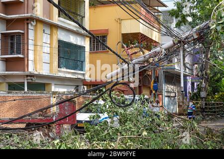 High tension electric wires hanging dangerously from a broken pole on a city road after cyclonic storm 'Amphan' struck landfall at Kolkata, India Stock Photo