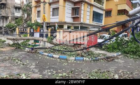 High tension electric wires hanging dangerously from a broken pole on a city road after cyclonic storm 'Amphan' struck landfall at Kolkata, India Stock Photo