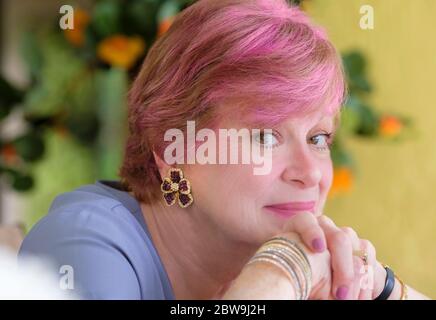 Portrait of smiling senior woman with pink hair Stock Photo