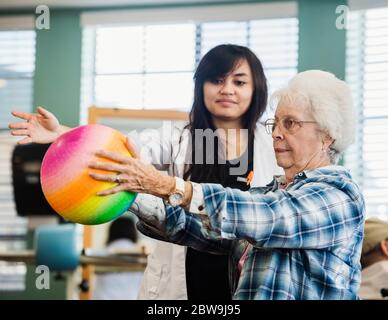 Senior woman exercising with therapist during physical therapy Stock Photo