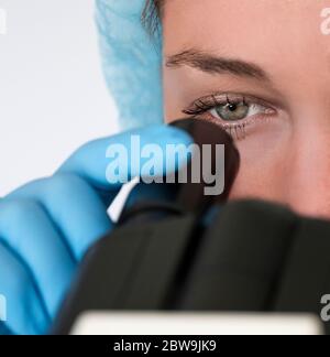 Laboratory technician looking through microscope Stock Photo