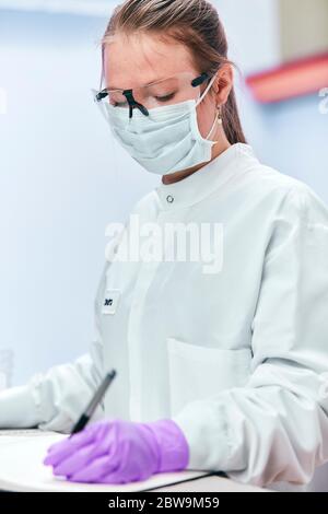 Female technician writing in notebook Stock Photo