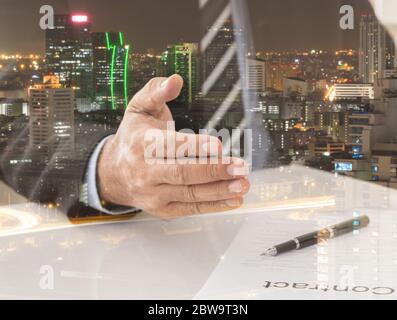 Business people giving him hand for handshake to partner with city background. Concept of Business Agreement, Partnership, Acquisition, Merger, Congra Stock Photo
