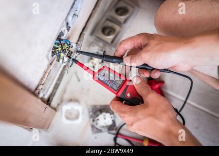 Closeup of electrician hands fixing a socket. Stock Photo