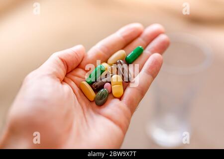 Immune system boost with vitamins. Colorful pharmaceutical medicine pills, narcotic drugs and vitamin in capsules on palm. Copy space for text. Stock Photo