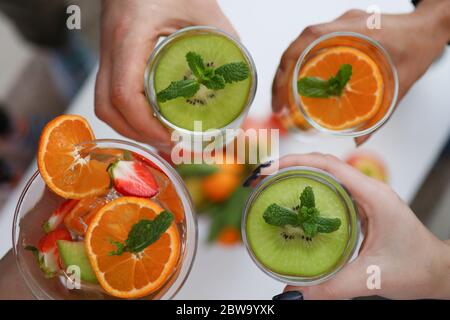 People holding glasses with bright fruit drinks Stock Photo