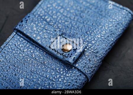 Blue leather wallet on a black textured background. Stock Photo