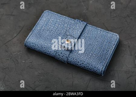 Blue leather wallet on a black textured background. Stock Photo