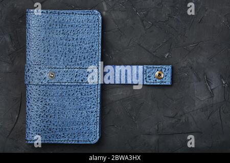 Blue leather wallet on a black textured background. Stock Photo