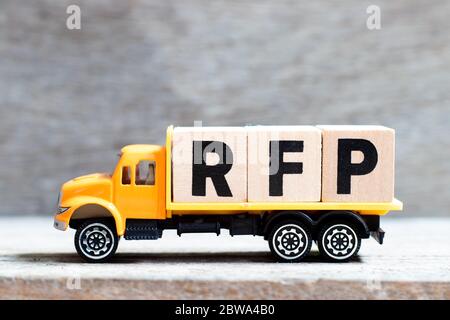 Truck hold letter block in word RFP (Abbreviation of request for proposal) on wood background Stock Photo