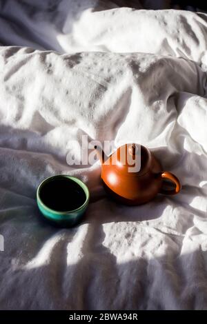 Chinese red clay pot and small cup on white cloth Stock Photo